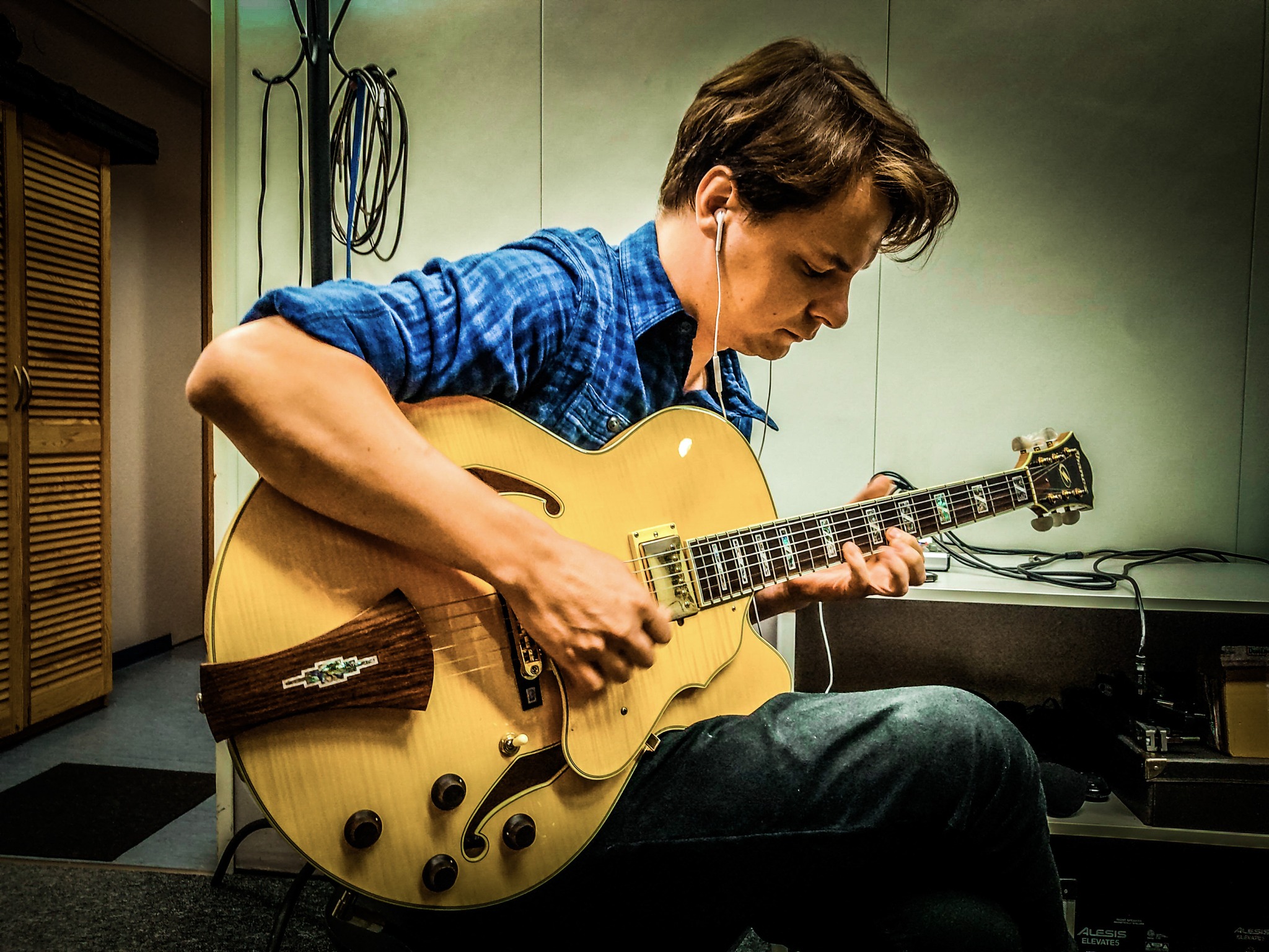 Mateusz Biliński grający na gitarze w pracowni muzycznej